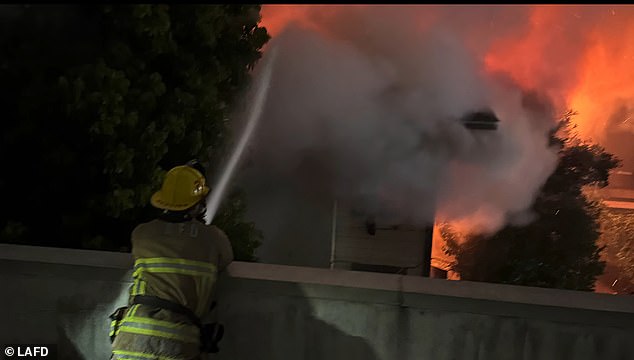 Flames pour from both floors of the Hollywood Center Motel before dawn as firefighters arrive