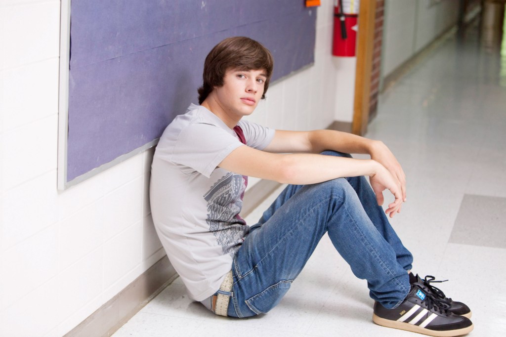 Matt Prokop from the movie Furry Vengeance, sitting against a purple bulletin board.