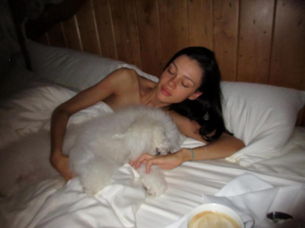 Nicola Peltz with her dog in bed.