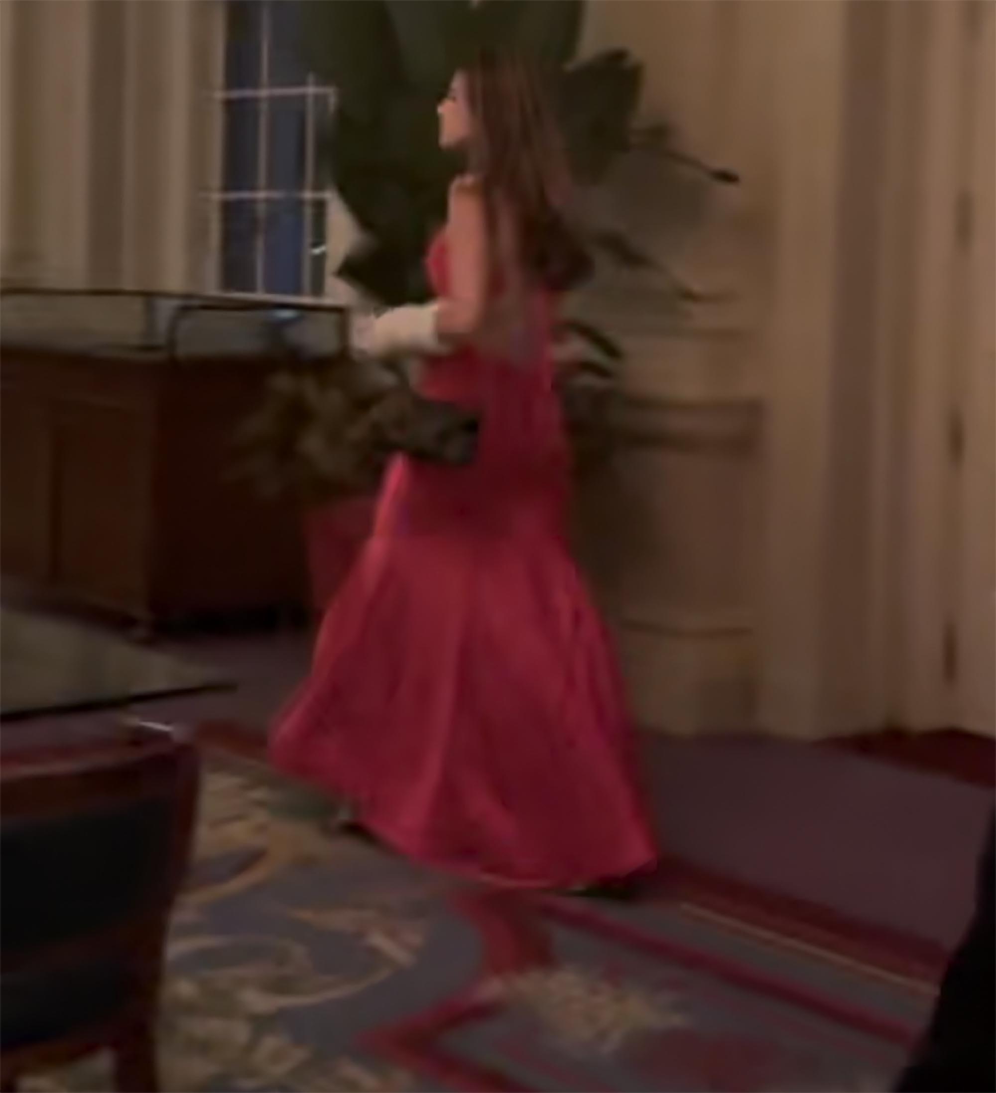 Kai Trump in a red silk cutout dress at Tiger Woods' 50th birthday party.