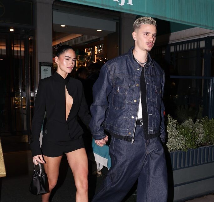 Romeo Beckham and Kim Turnbull holding hands and walking in Paris during Fashion Week.