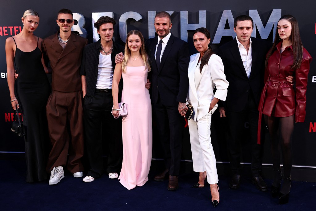 David and Victoria Beckham pose on the red carpet with their children and partners at the premiere of "Beckham."