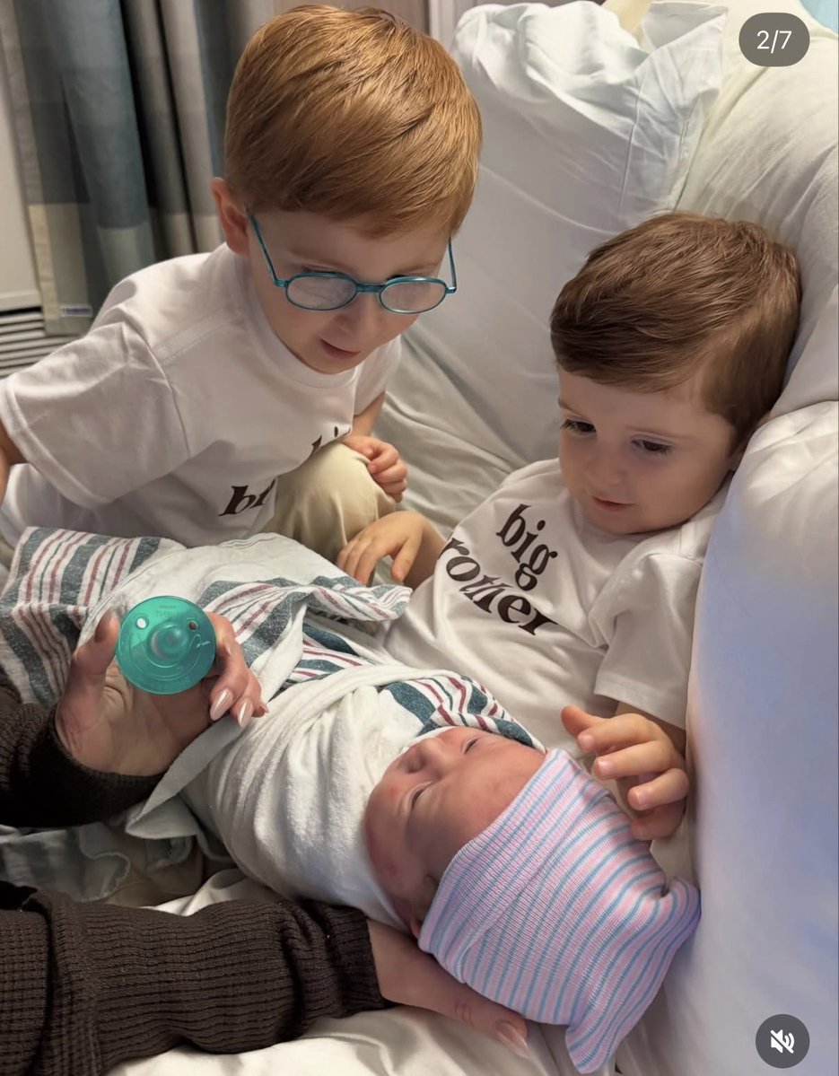 Riley and Barry Sabara looking down at their baby sister, Mikey Moon.