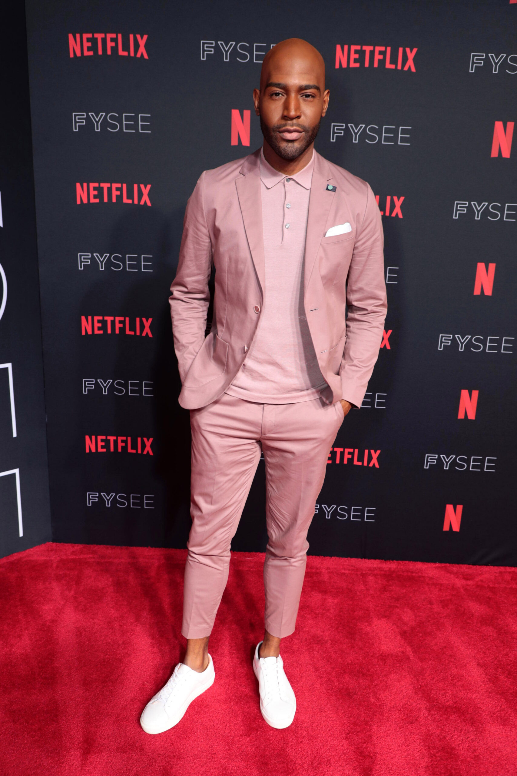 Karamo Brown poses on a red carpet at the Netflix FYSEE Queer Eye Panel event.