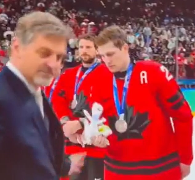 MacKinnon receives the Milan Games mascot 'Tina' alongside his silver medal