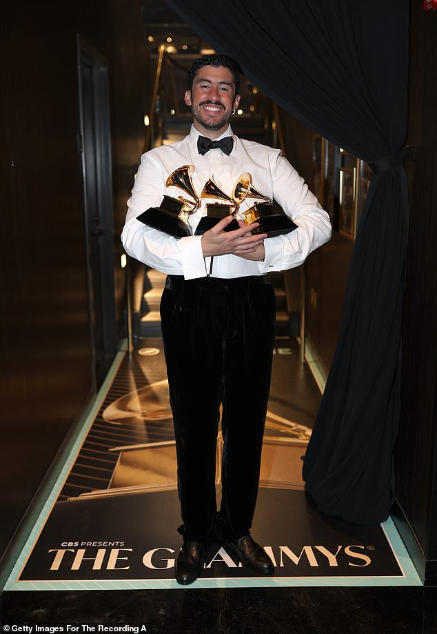 Bad Bunny holding multiple Grammy Awards on stage