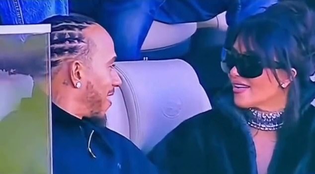 Kim Kardashian and Lewis Hamilton at the Super Bowl, seated together in black looks with a diamond earring catching the light