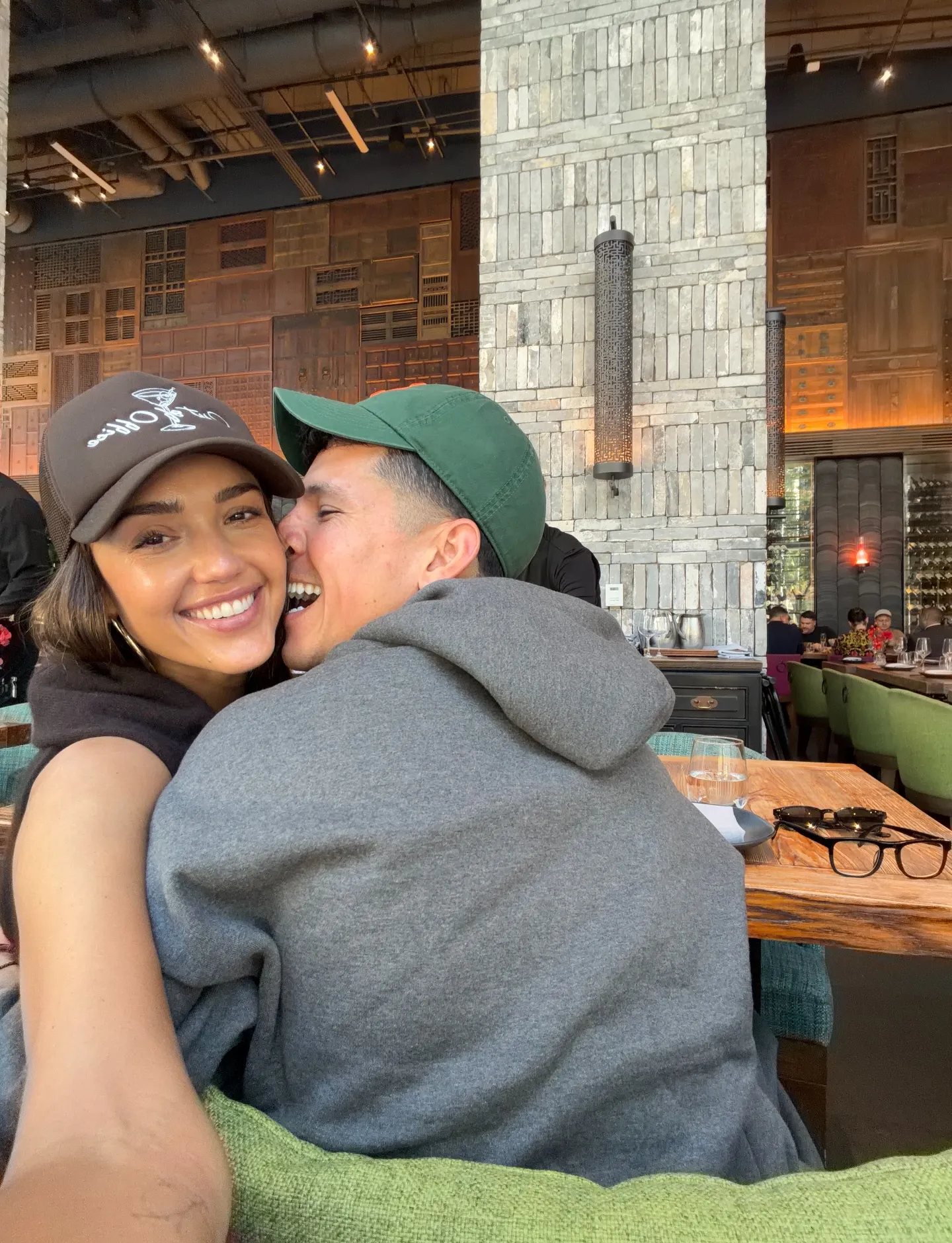 Jessica Alba and Danny Ramirez snuggling at a restaurant.