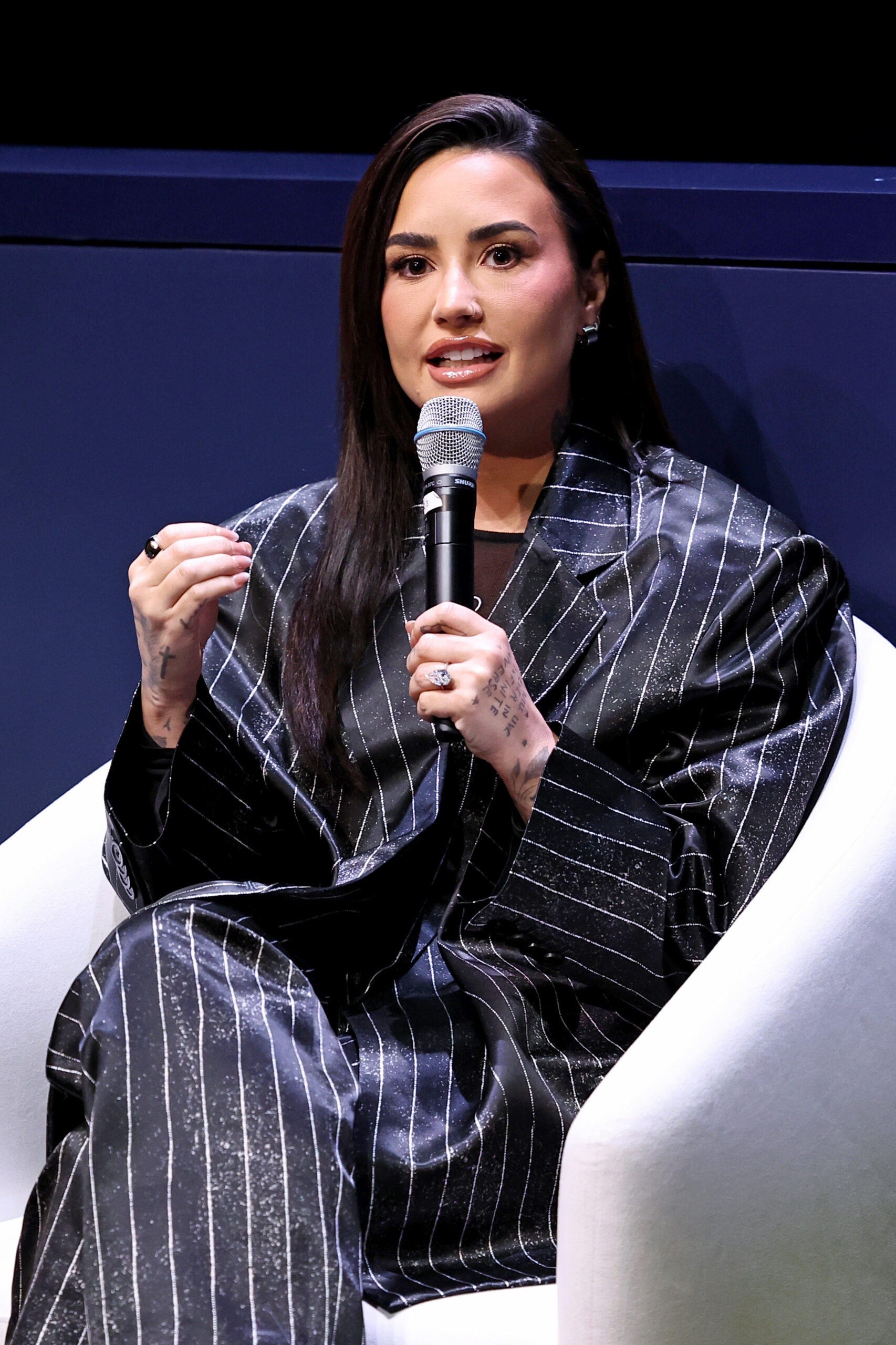 Demi Lovato speaking onstage at a mental health event.