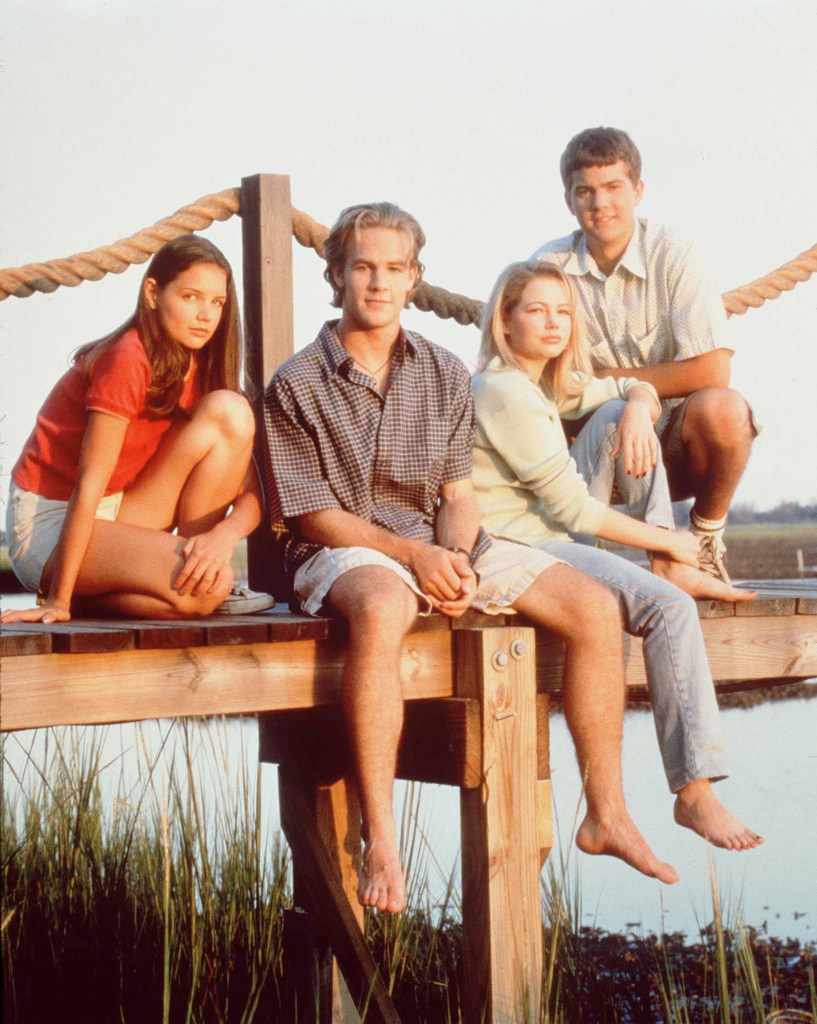 The Dawson's Creek cast sitting together on a pier in a classic promotional photo.