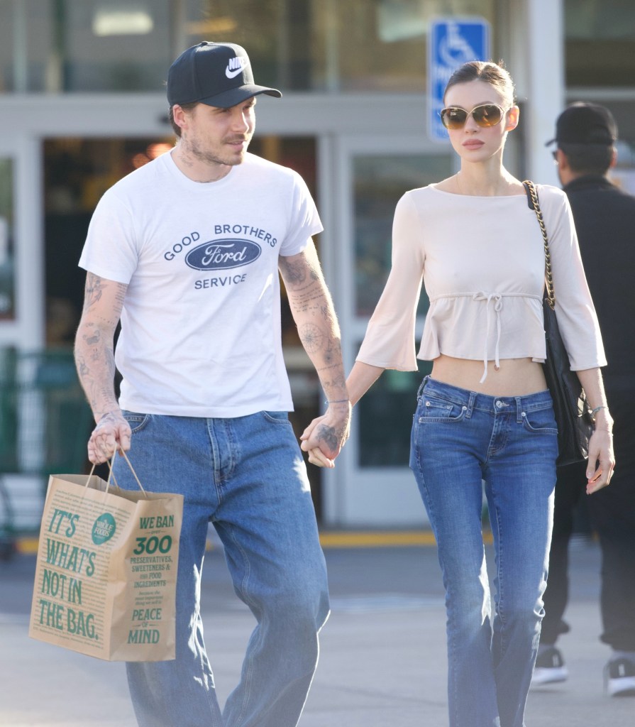 Brooklyn Beckham, wearing a 'Good Brothers' t-shirt, and Nicola Peltz holding hands in front of a Whole Foods.