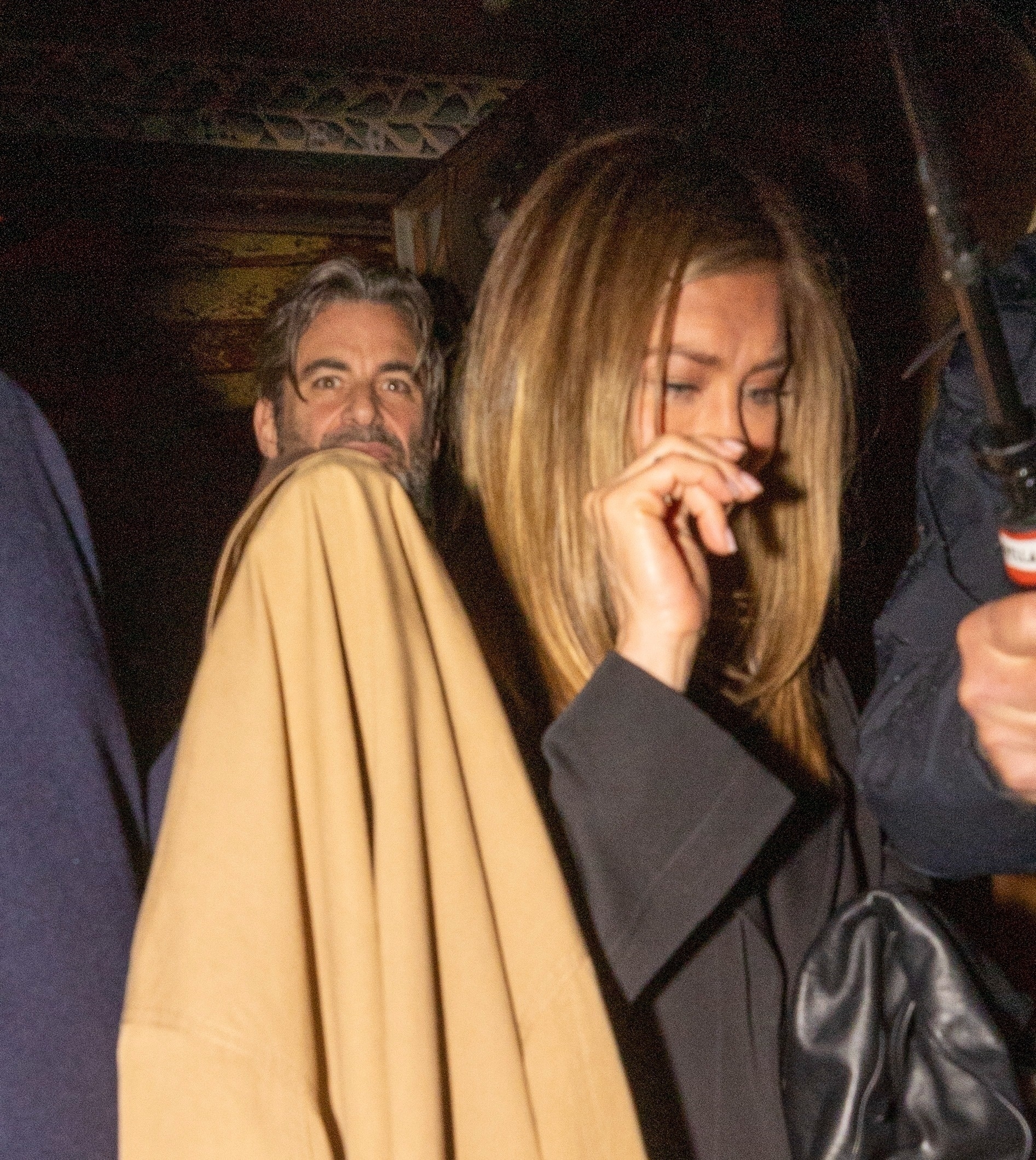 Jennifer Aniston and Jim Curtis leaving a restaurant together in the rain.
