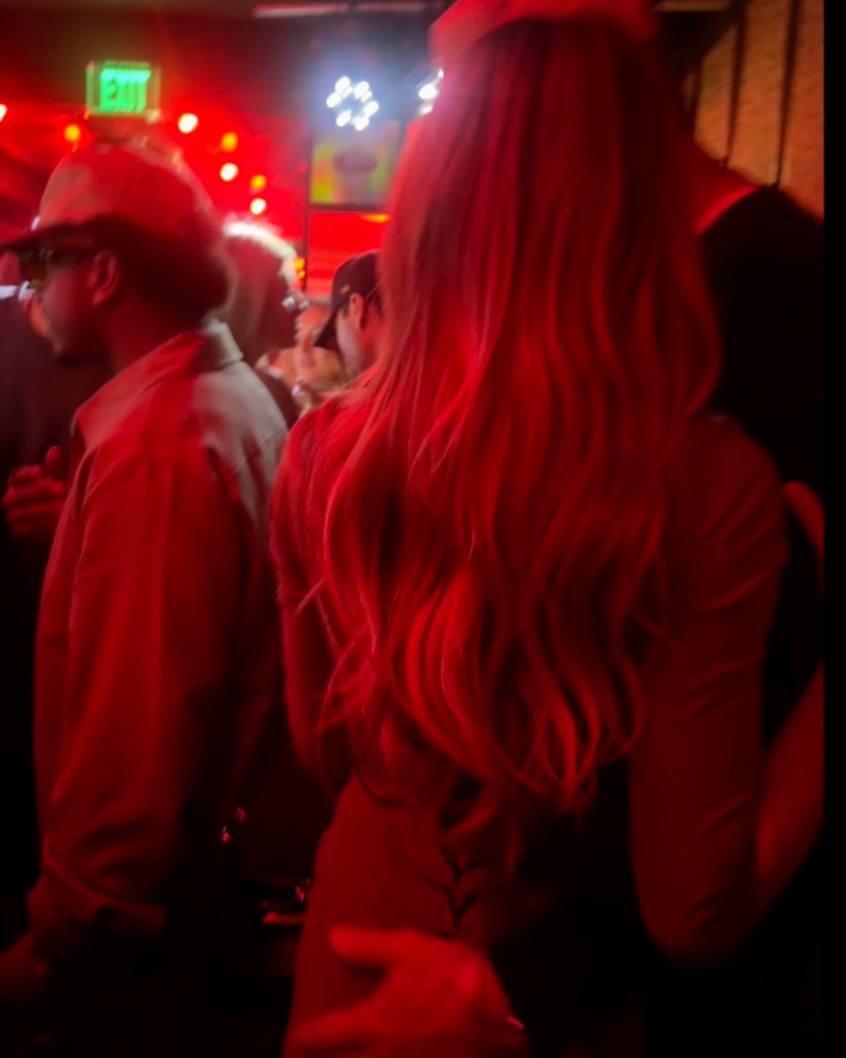 Tom Brady with his arm around Alix Earle's lower waist at a Super Bowl party.