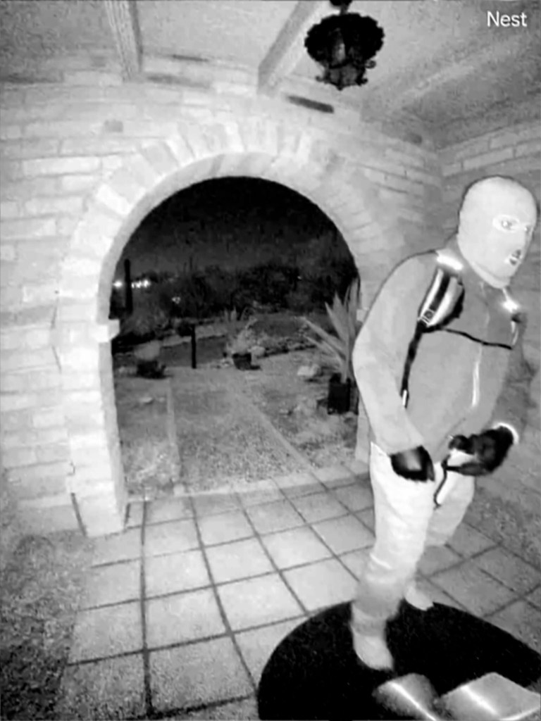 Doorbell-camera still showing a masked person with a backpack outside a home at night.