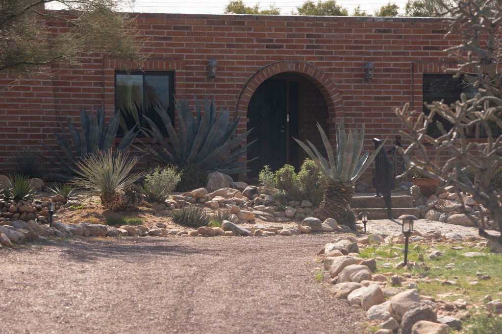 Exterior of Nancy Guthrie's Tucson-area home with arched entry and xeriscaped yard.