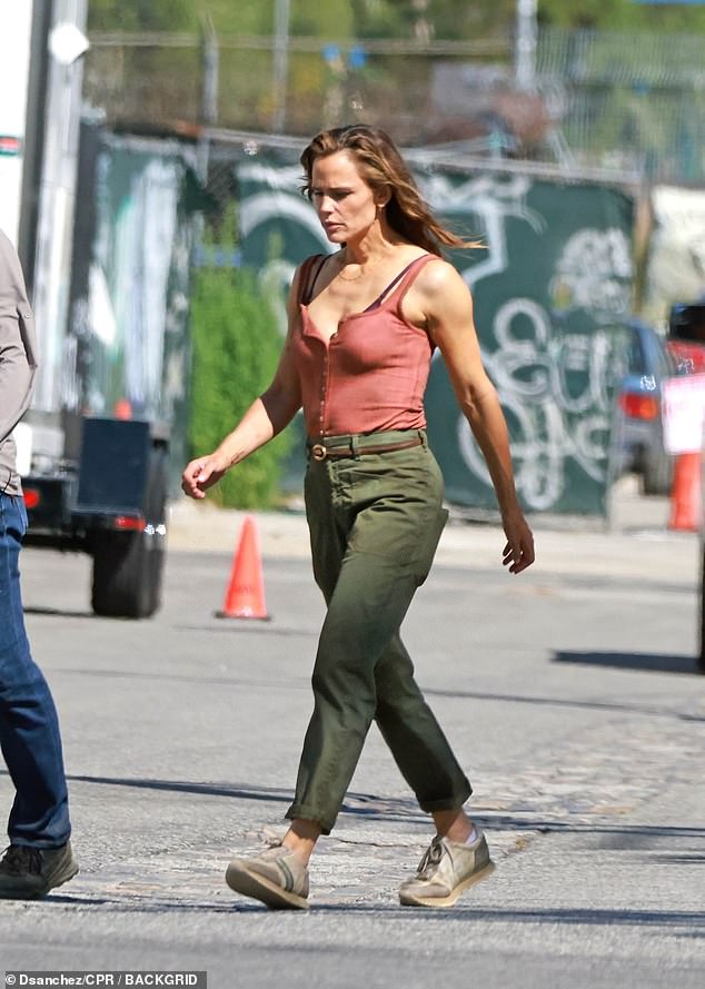 On-set look: pink button-front tank with a peek of purple sports bra, green cargo pants and sneakers.