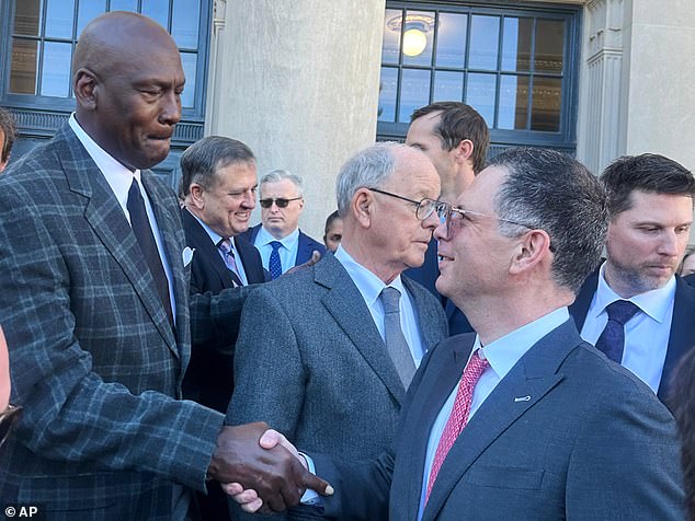 Michael Jordan shares a handshake amid discussions around NASCAR's charter settlement