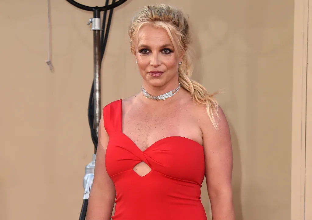 Britney Spears on the red carpet in 2019 wearing a red dress and choker.