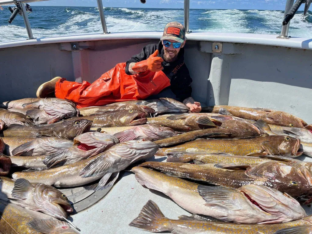 Todd Meadows on a boat surrounded by his catch of fish.