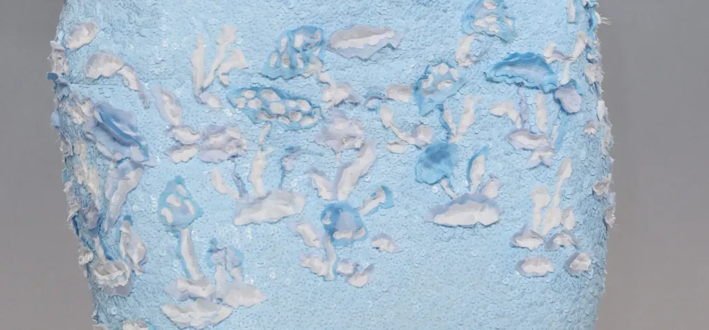 Close-up of Kendall Jenner's Chanel gown showing the subtle mushroom motif and layered blue-and-white embellishments.