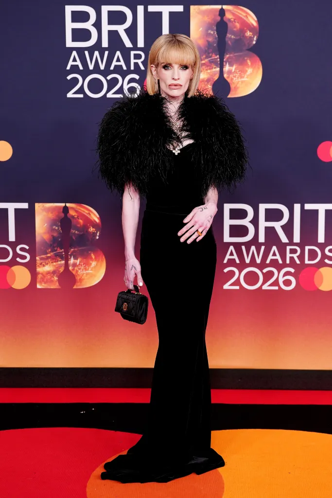 Kelly Osbourne shows her black feathered gown on the BRIT Awards 2026 red carpet.