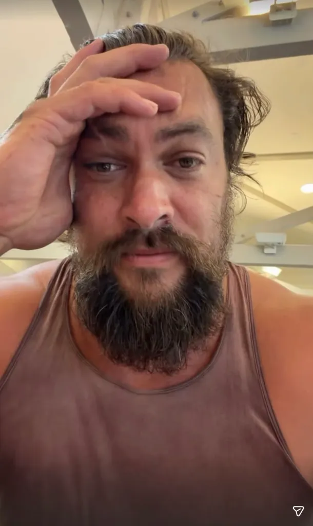 Jason Momoa looks solemn with his hand on his forehead in a selfie video posted to Instagram during the Oahu floods.