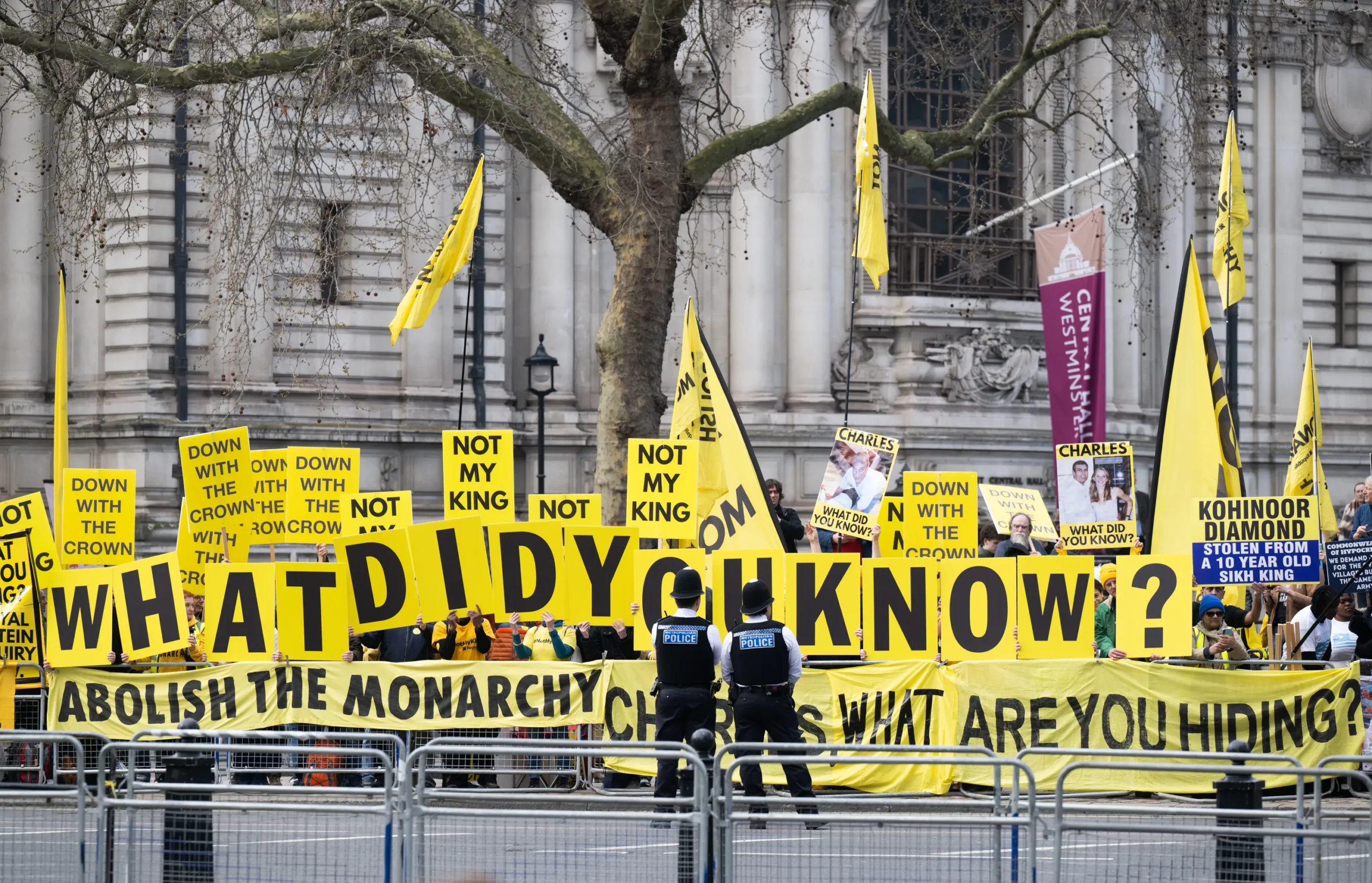Protesters display large yellow 'What did you know?' letters outside Westminster Abbey on Commonwealth Day.