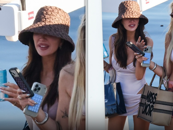 Kate Cassidy celebrates her birthday on a boat in Miami Bay, wearing a white one-piece swimsuit and a bucket hat