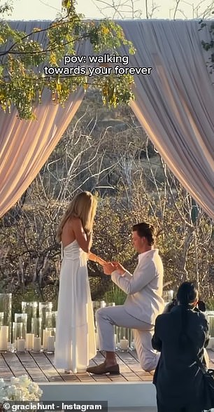 Derek Green kneels to propose and places the ring on Gracie Hunt's finger