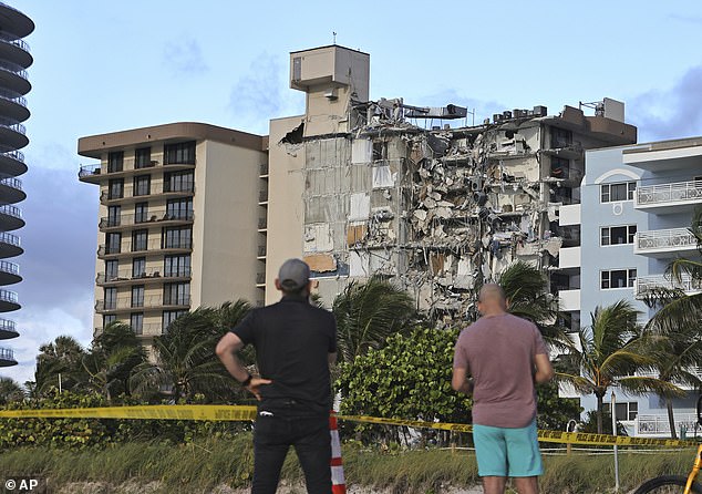 People look toward the partially collapsed Champlain Towers South in Surfside, Florida, on June 24, 2021.