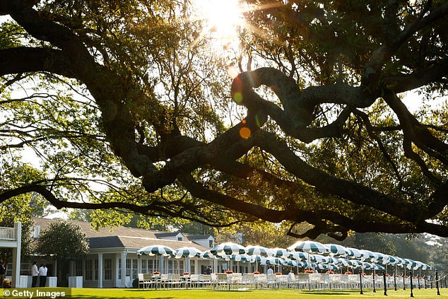 Crowds gather under Augusta National's Big Oak Tree beside the clubhouse during the Masters