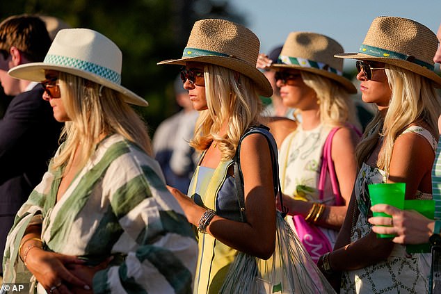 Patrons watch the action on the 17th hole at Augusta National during the Masters, many wearing sunglasses.