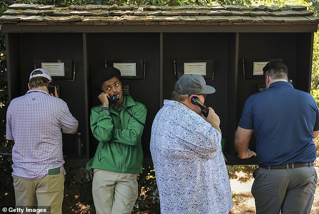 Patrons use on-course courtesy telephones during the Masters at Augusta National, reflecting the no-phones policy.