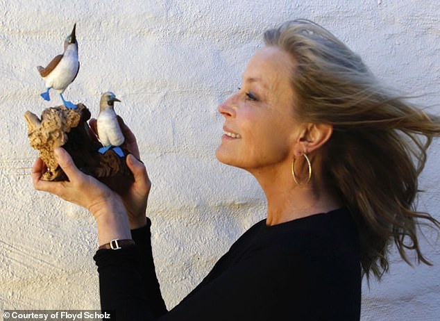 Actress Bo Derek poses with her pair of blue-footed boobies carving, created by Scholz, inspired by her travels to the Galapagos Islands