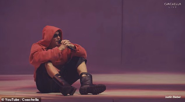 Justin Bieber seated on stage beside a laptop during his Coachella performance