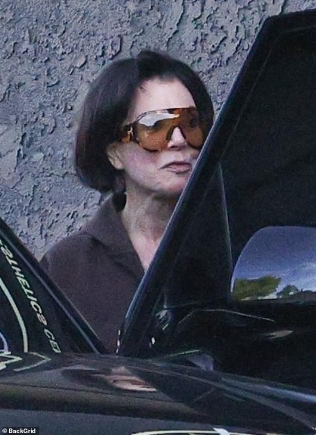 Kris Jenner leaves 7Q Spa in Los Angeles wearing sunglasses and a brown hoodie.