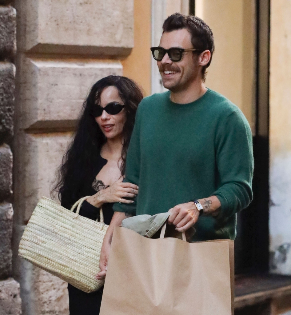 Harry Styles and Zoe Kravitz enjoying an evening stroll through the streets of Rome, holding hands and carrying shopping bags.
