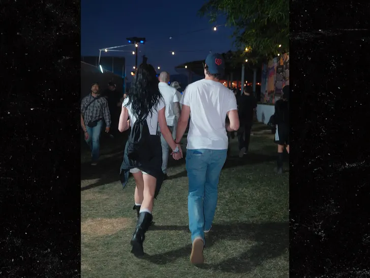 Katy Perry and Justin Trudeau walking hand-in-hand at Coachella during a nighttime set.