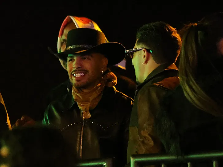 Rauw Alejandro keeps a low profile with a gold bandana at Neon Carnival