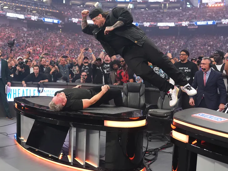 Jelly Roll launches off the announce table to elbow Pat McAfee through a table during WrestleMania at Allegiant Stadium.