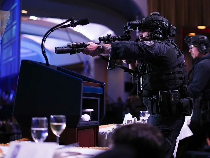 Security officer aims a weapon on stage during the White House Correspondents' Dinner amid reports of gunfire