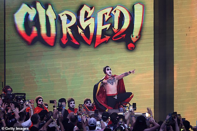 WWE star Danhausen performs his signature 'curse' gesture for fans.