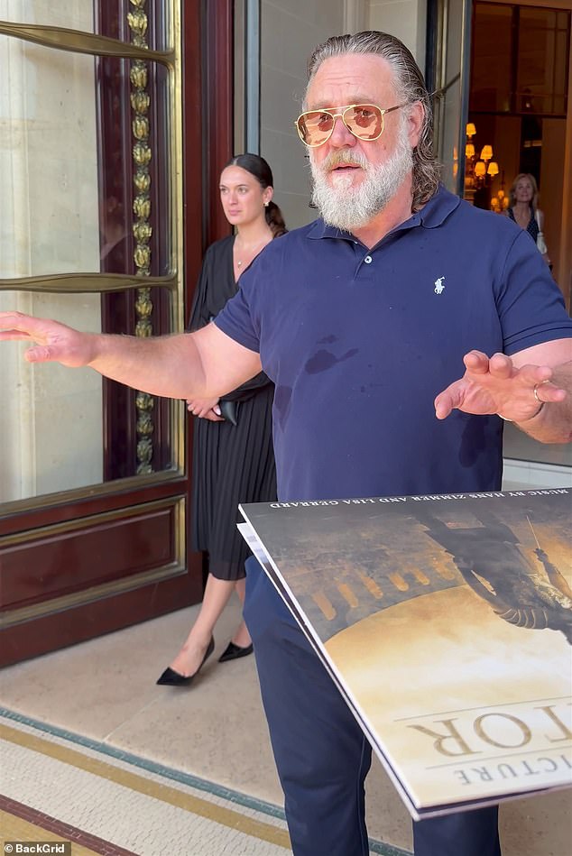 Russell Crowe addresses autograph seekers outside a Paris hotel before signing.