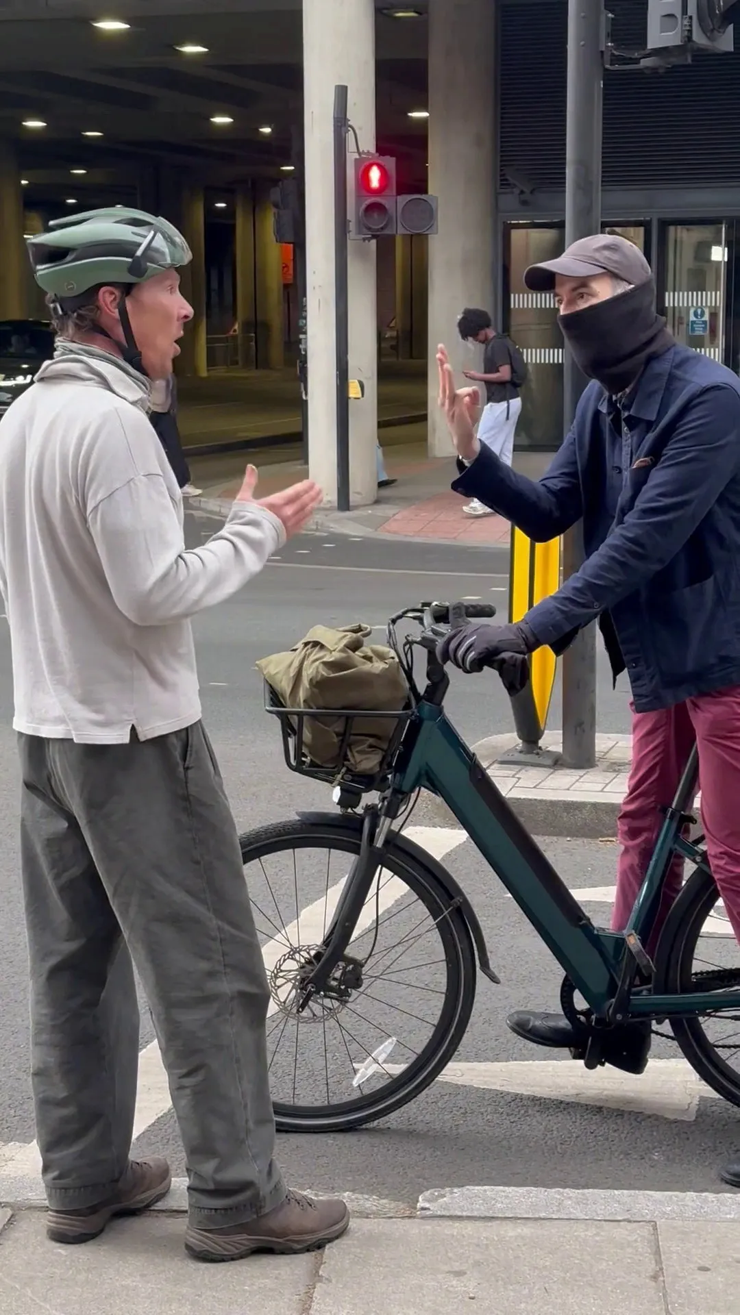 Cumberbatch stands by his bike as the masked cyclist argues that he ran a red light.