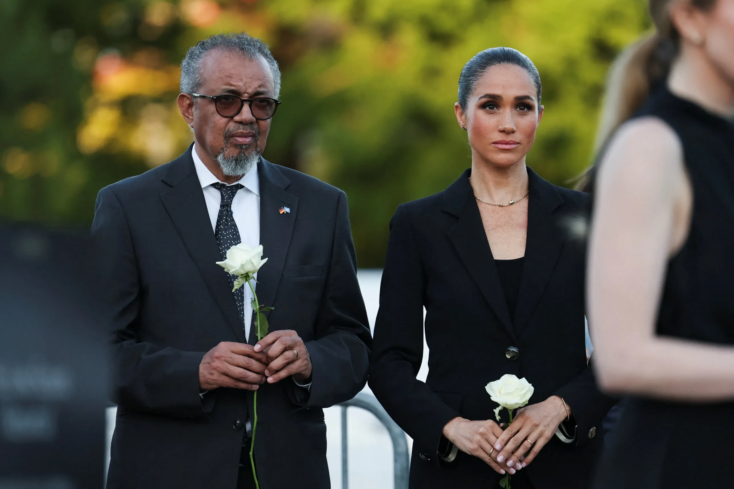 Meghan Markle and WHO Director-General Tedros Adhanom Ghebreyesus carry white roses while viewing the Lost Screen Memorial in Geneva.