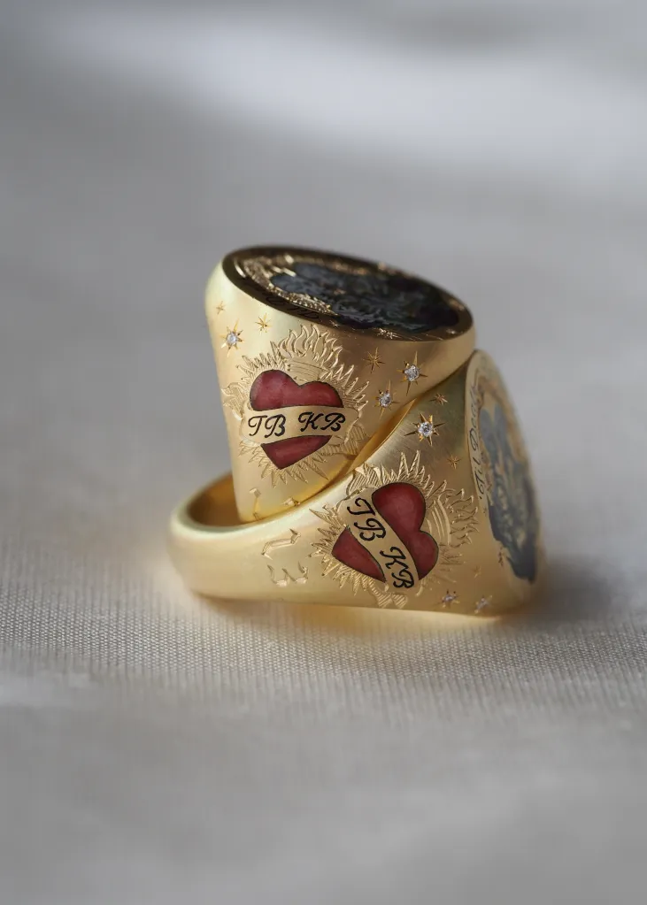 Side view of the custom Cece Jewellery rings showing flaming red hearts with a 'TB KB' banner and the number 13.