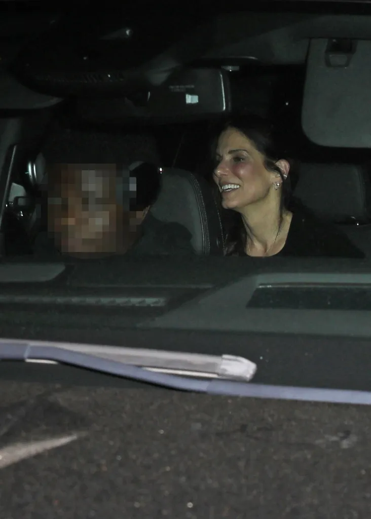 Sandra Bullock rides in a car at night beside her son Louis in October 2024, with his face pixelated for privacy.