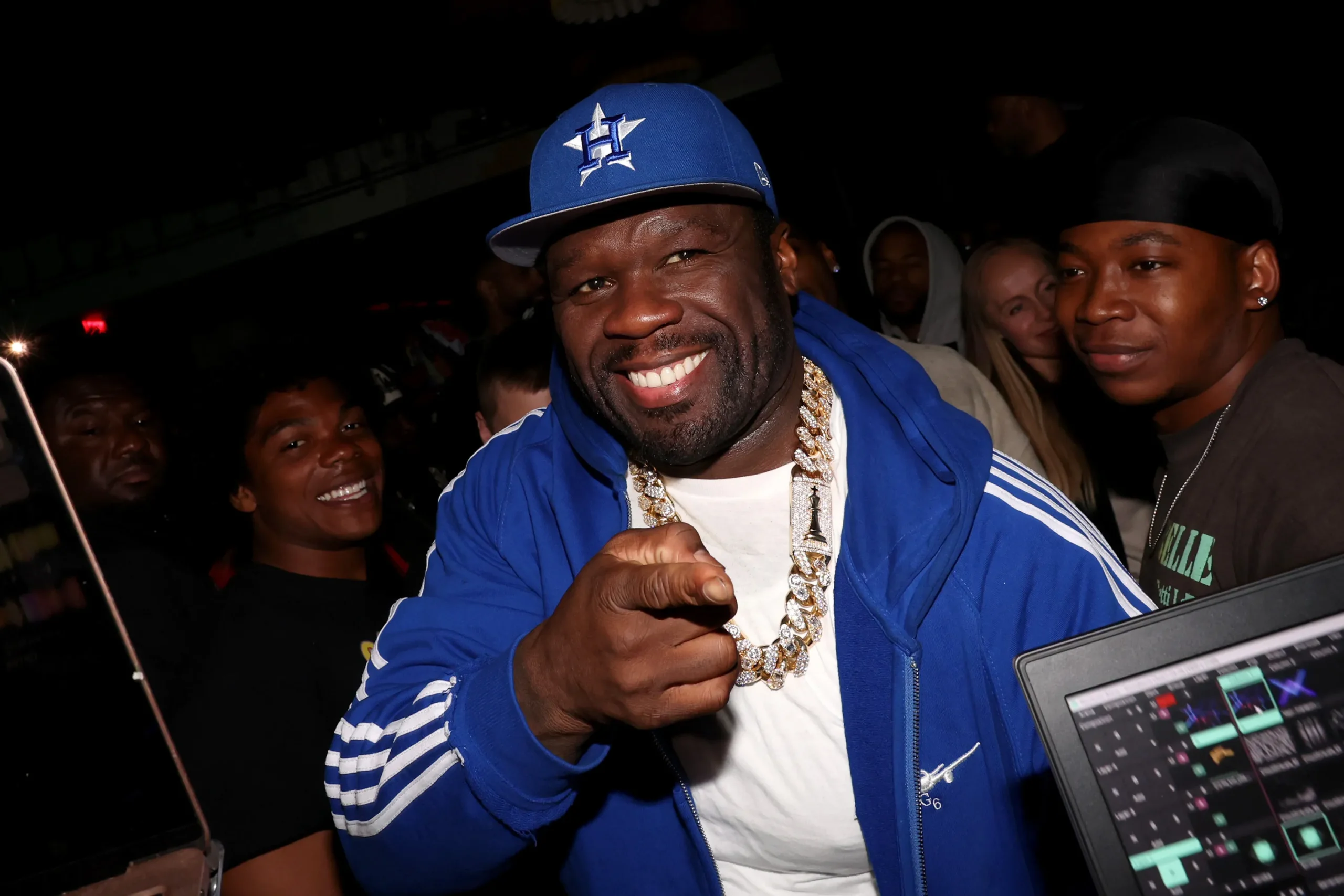 Rapper 50 Cent smiles and points toward the camera during an appearance.