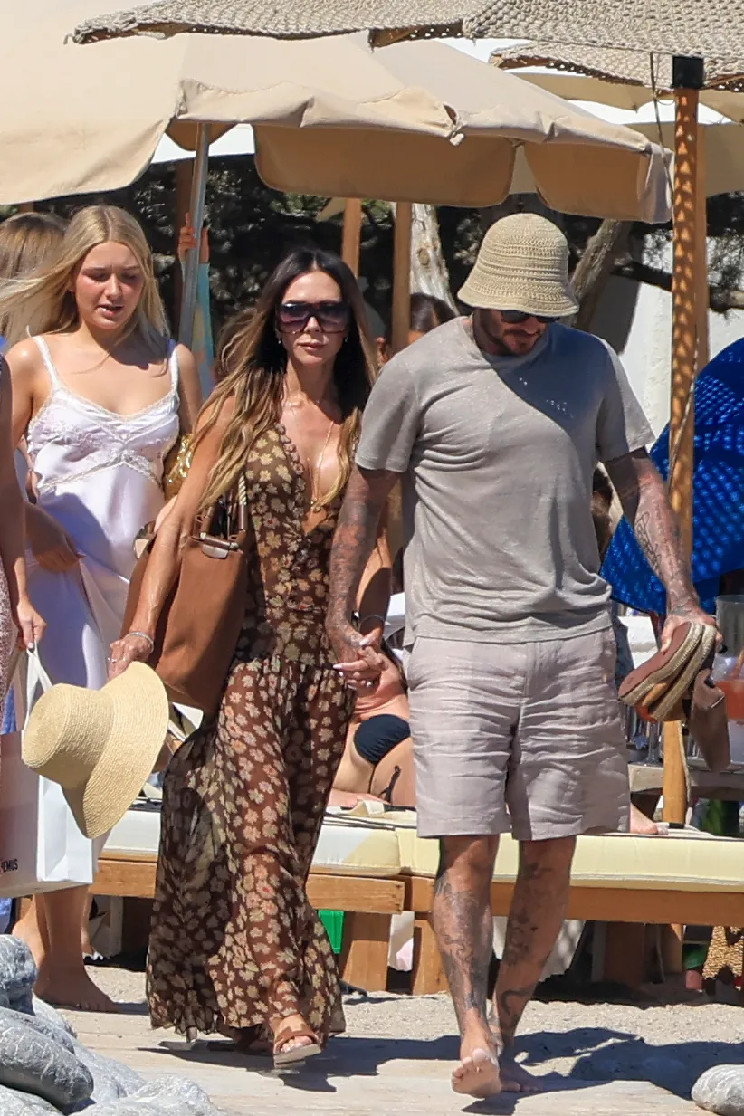 Victoria and David Beckham hold hands on the beach during their Ibiza getaway.