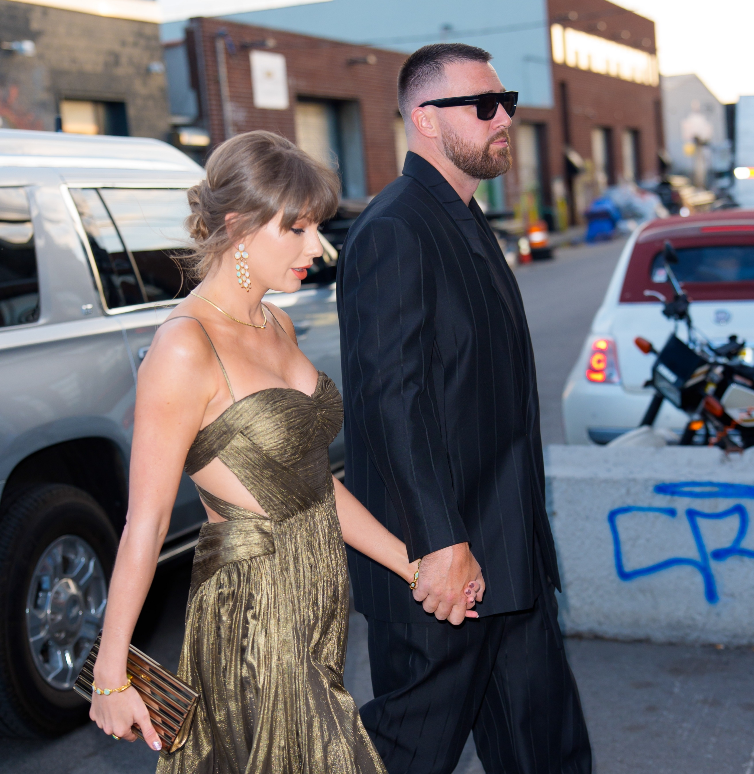 After dinner, Taylor Swift wears Travis Kelce's blazer as the couple leave hand-in-hand.